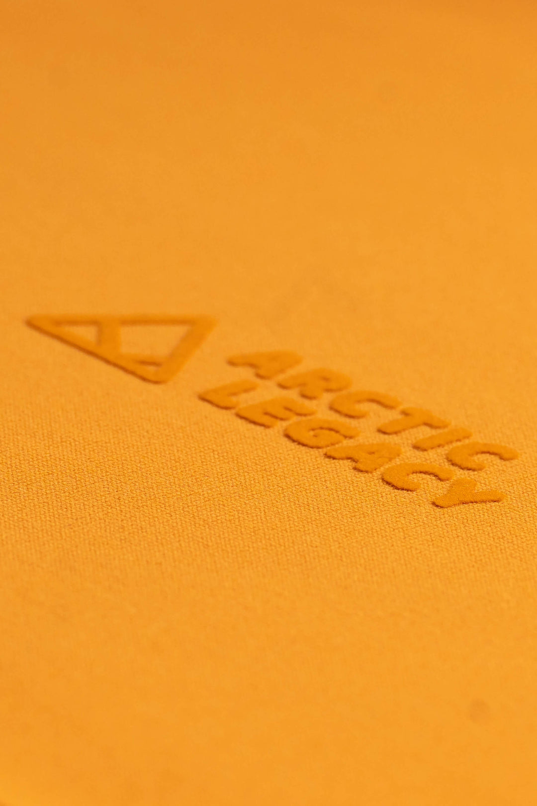 Women's orange yellow fleece jacket - close-up view of the Arctic Legacy Nanuk Pro Fleece Hoodie#color_zinnia