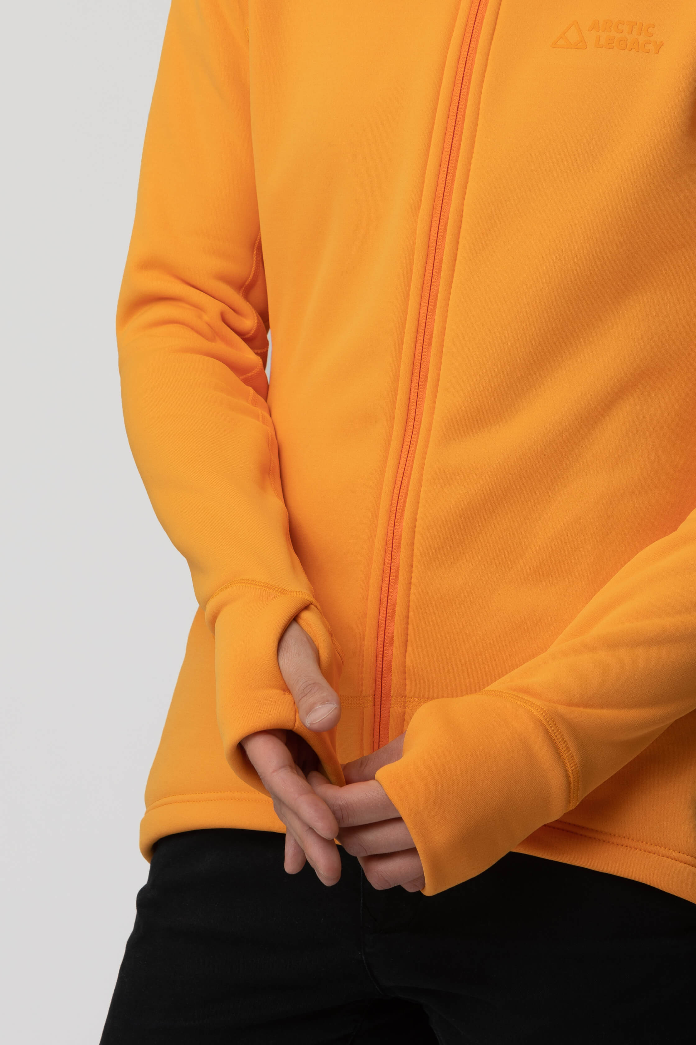 Women's orange yellow fleece jacket - hands view of the Arctic Legacy Nanuk Pro Fleece Hoodie#color_zinnia
